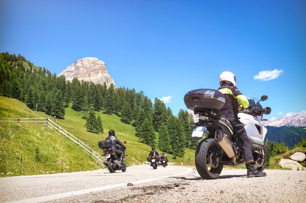 Motorradfaherer:in macht eine Pause und genießt die Aussicht über die Dolomiten auf einer Tour mit Fahrsicherheitstraining der DFSG