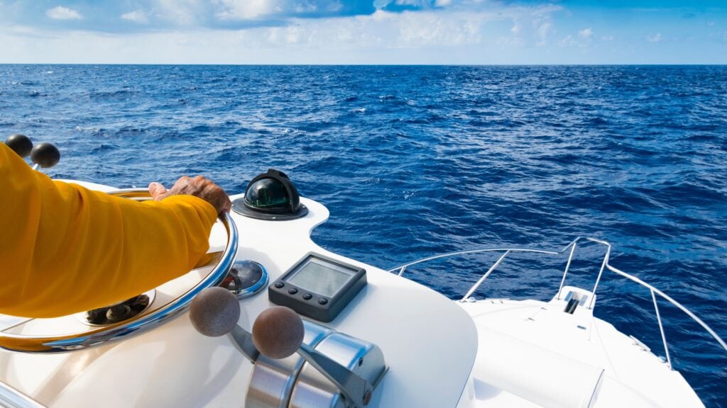 Mann navigiert Motorboot dank Manövertraining sicher über das Wasser