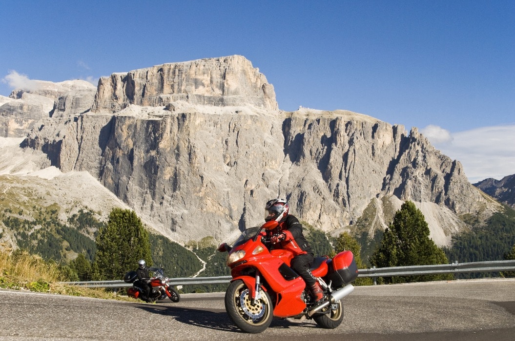 Zwei Motorradfahrer:innen kurven dank des Fahrsicherheitstrainings der DFSG sicher durch die Dolomiten