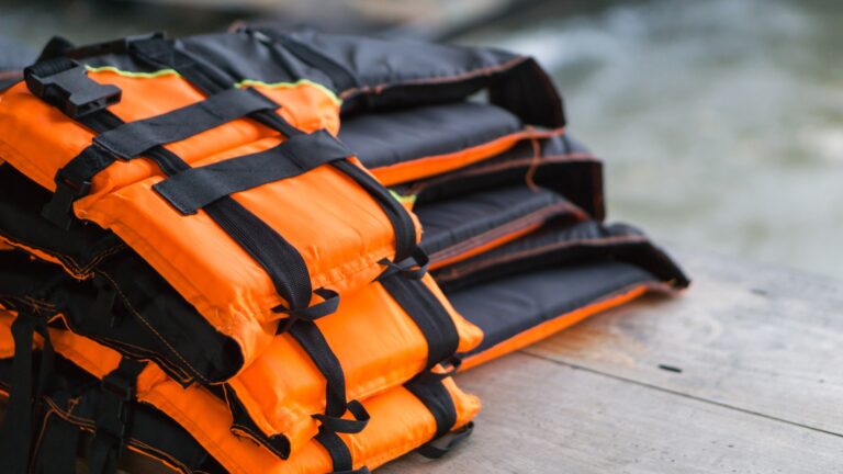 Nahaufnahme Schwimmweste auf Holztisch mit Fluss Hintergrund