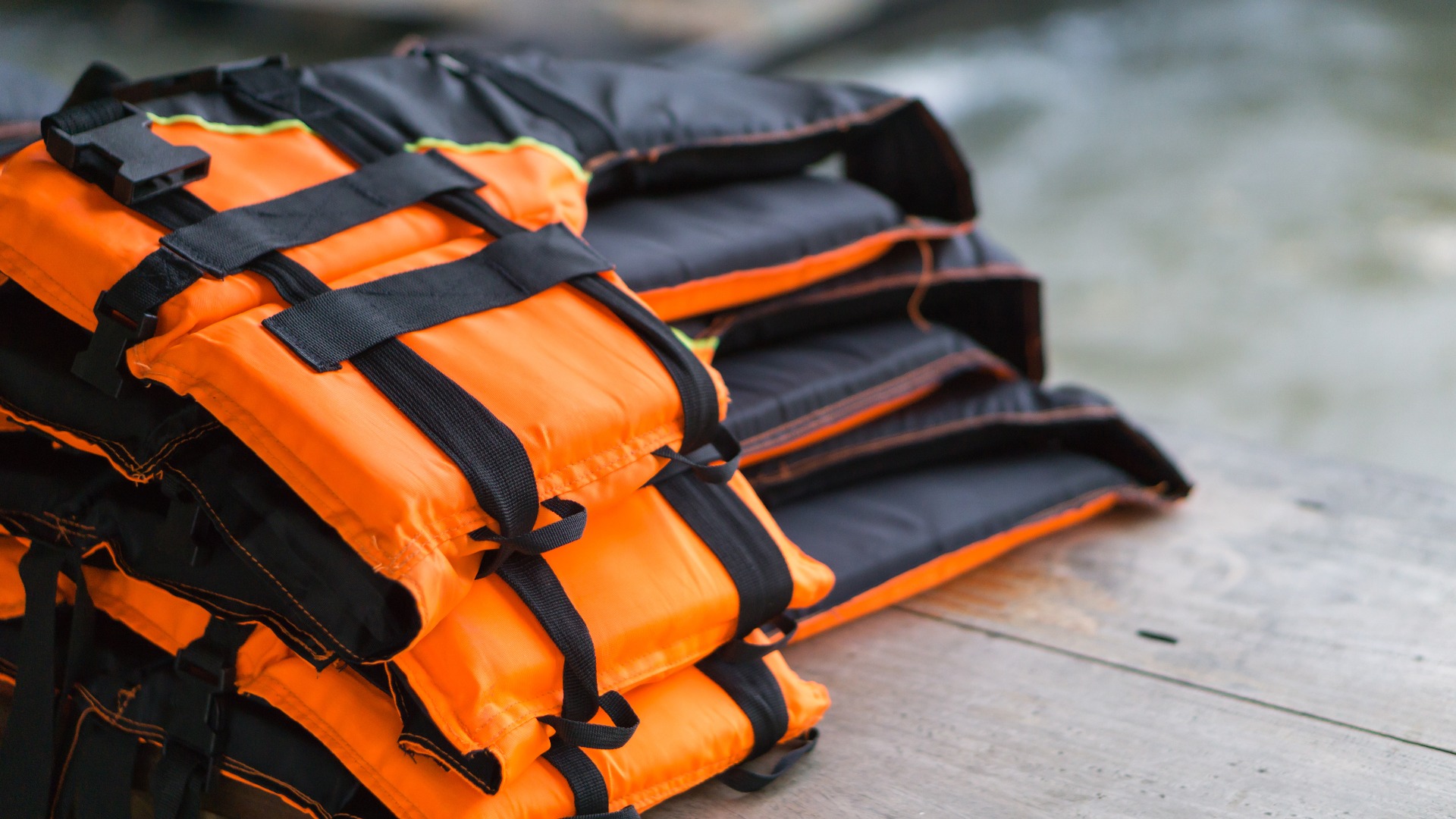 Nahaufnahme Schwimmweste auf Holztisch mit Fluss Hintergrund